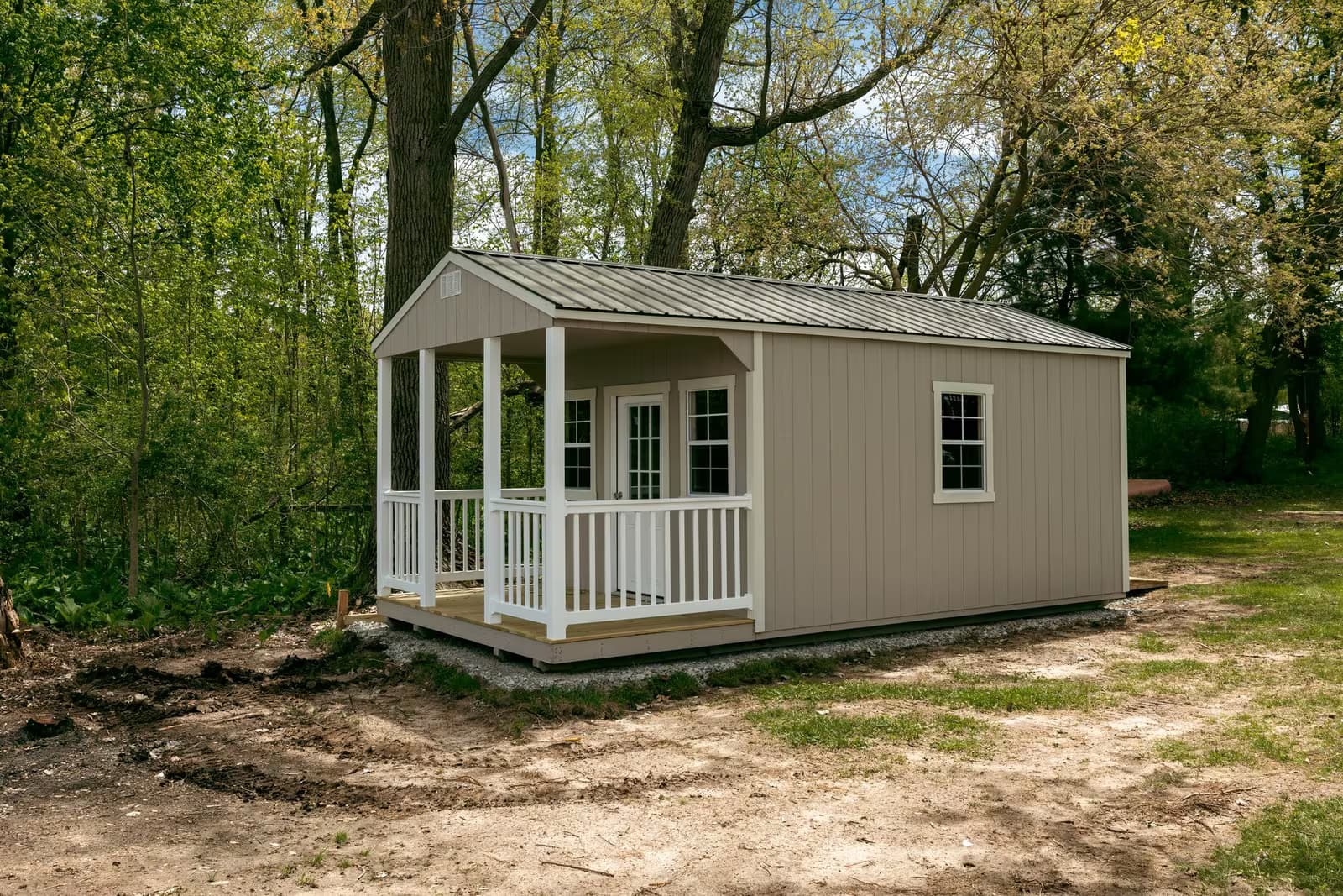 Amish-built casita with a covered porch on a wooded property in Southern Michigan