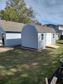 Amish-built lofted garden shed with vinyl siding at a customer property in Southern Michigan
