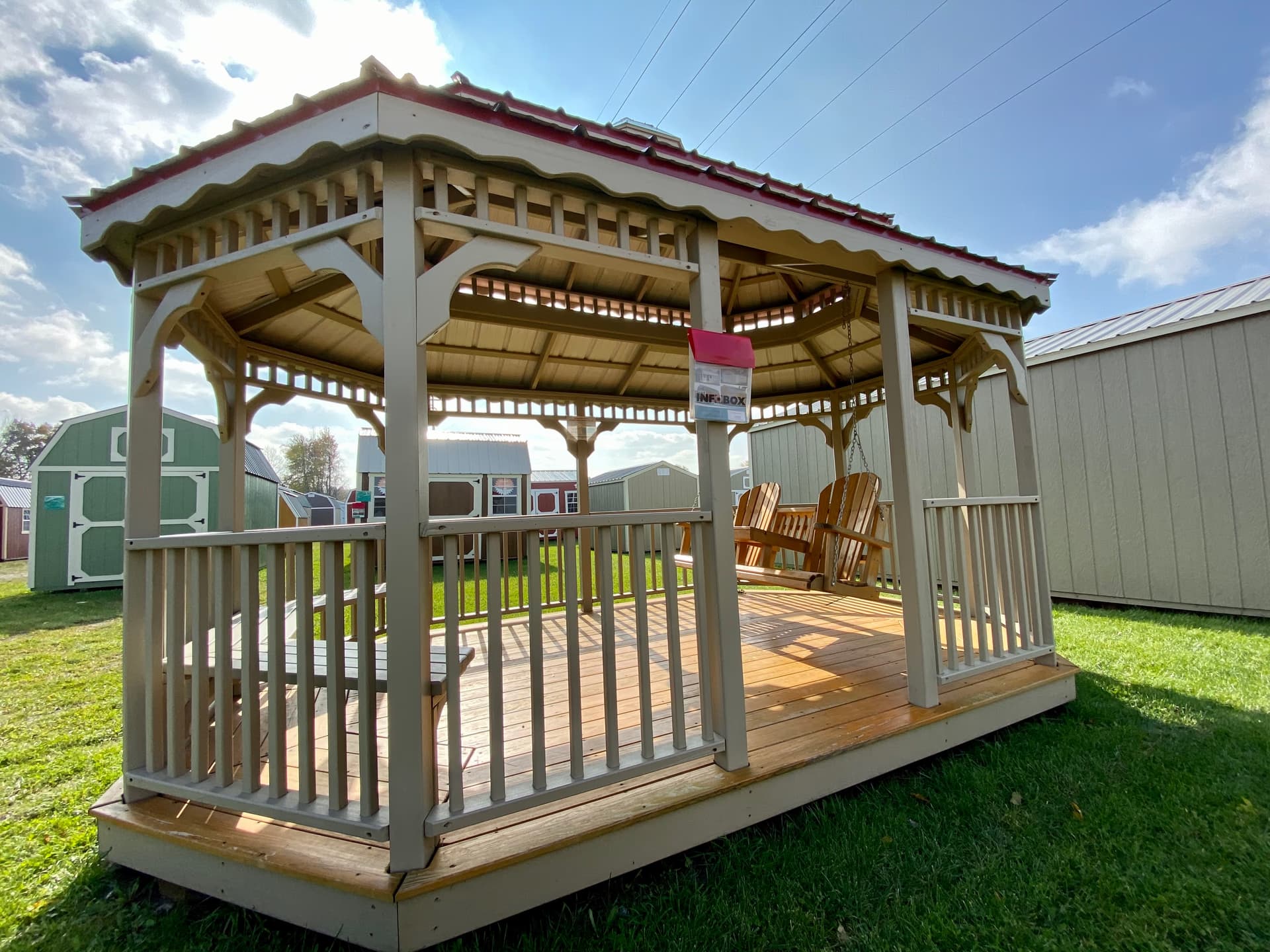 Amish-built double roof gazebo in cream with red trim and Adirondack chairs