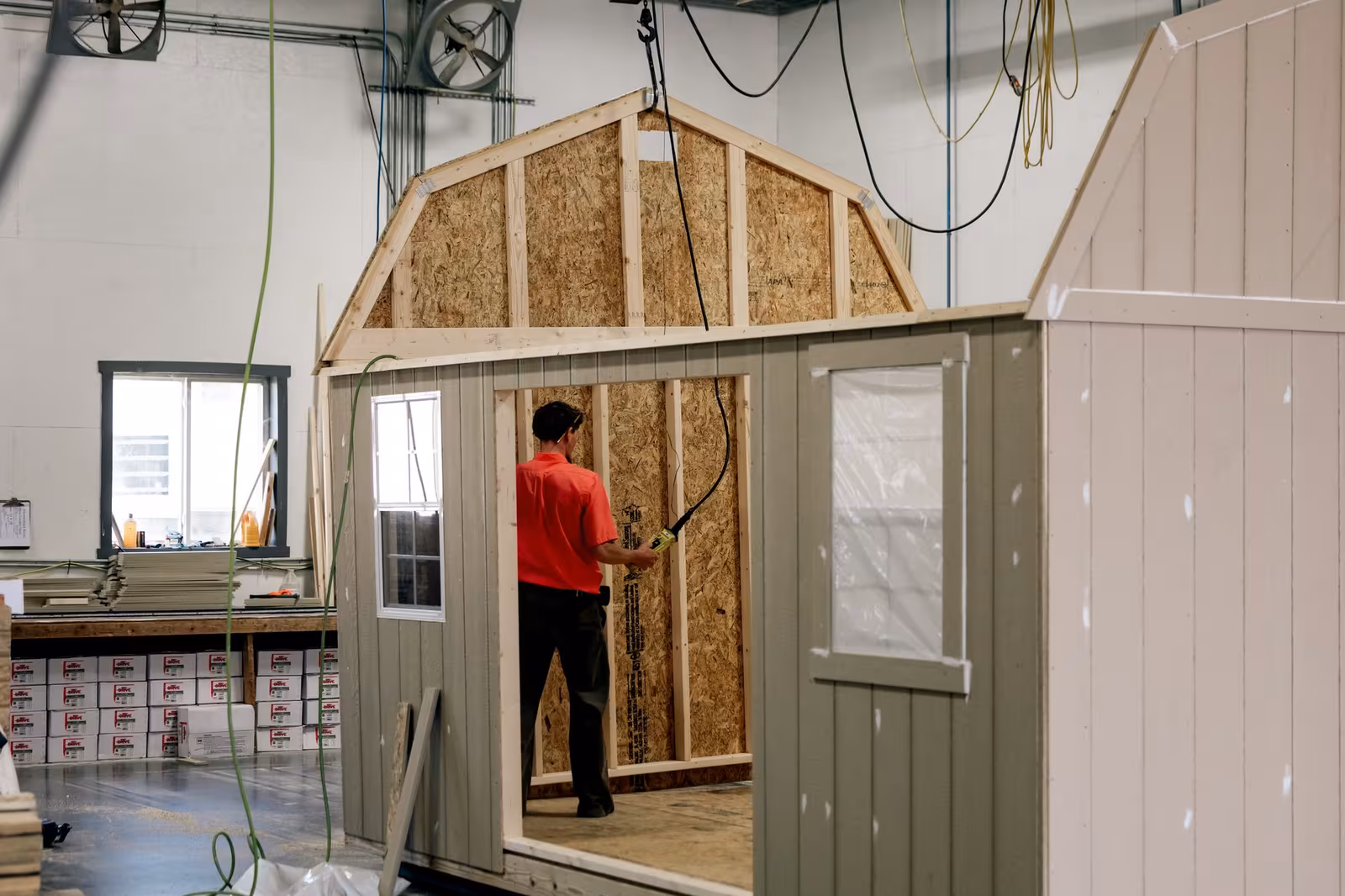 An Amish builder framing a door opening on a shed in the workshop
