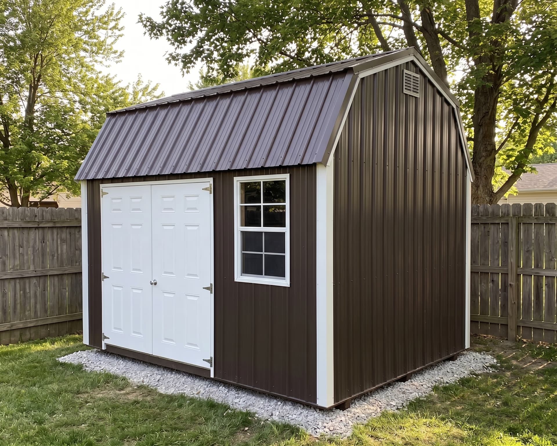 Brown Amish-built metal lofted garden shed with a gambrel roof in a fenced backyard